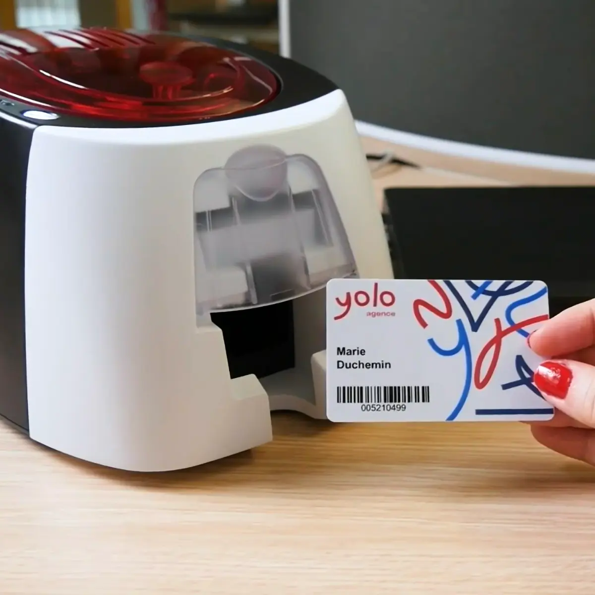 Exemple de badge imprimé avec la Badgy 200 tenu devant l’imprimante