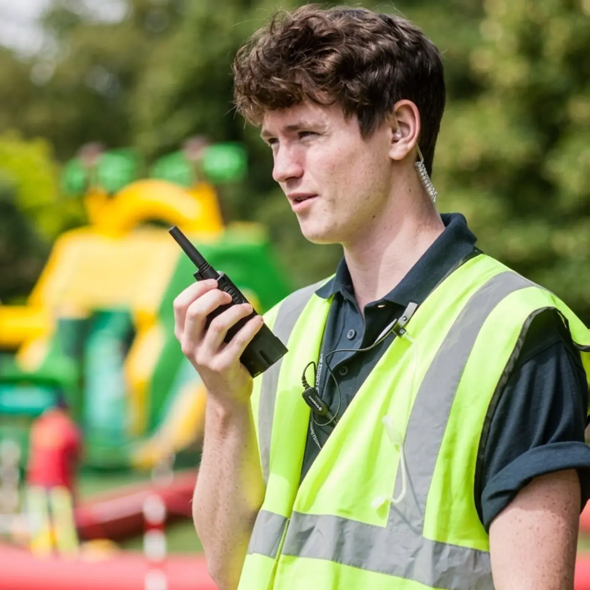 Talkie-walkie Motorola XT420 utilisé en extérieur avec oreillette pour l'encadrement et la sécurité.
